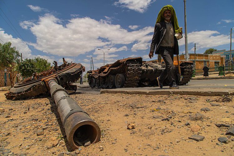 Wikipedia: A man passes by a destroyed tank on the main street of Edaga Hamus, in the Tigray region, in Ethiopia, on June 5, 2021.